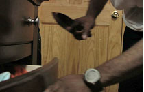 Gallery image from movie. A man gets a knife from his drawer.
